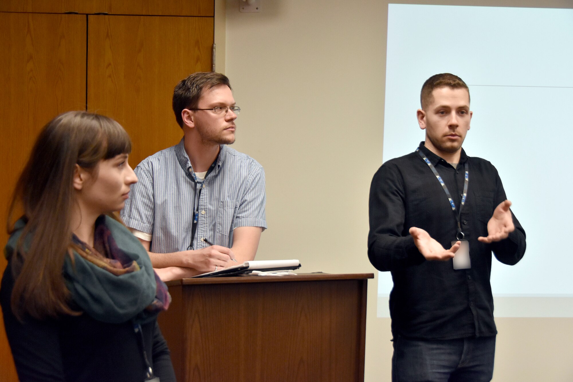 Tyler May, a modeling and simulation engineer with National Aerospace Solutions and president of the NextGen Board of Officers, responds to a question from an attendee of the March 29 NextGen kickoff meeting. NextGen was formed to provide networking and professional development opportunities to new NAS employees. Also pictured are Kassandra Brexel, NextGen networking chair, left, and Garrick Muncie, NextGen treasurer. (U.S. Air Force photo by Bradley Hicks) (This image has been altered by obscuring badges for security purposes)