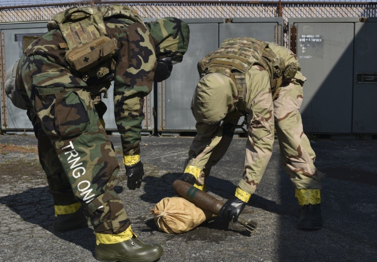 166th Airlift Wing explosive ordnance disposal technician Staff Sgt. Dominic Buckmuse, left, and team leader Staff Sgt. Seth Kohn work to identify an exercise munition at the New Castle Air National Guard Base April 7. A team of three Airmen worked in tandem to practice decontaminating, sealing and transporting potentially hazardous materials. In addition to supporting active duty overseas missions, the 166th EOD Flight supports several local counties. (U.S. Air Force Photo by Capt. Logan Clark)