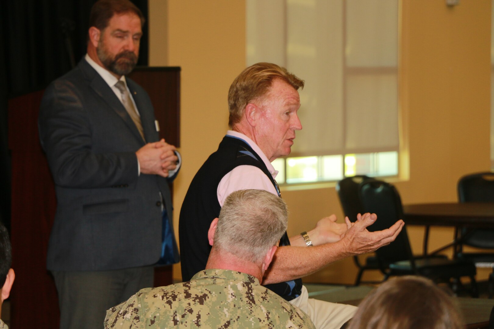 Mike Cannon, DLA Disposition Services director, pauses during his remarks as an attendee from Naval Air Station Jacksonville shares how DLA Disposition Services has helped clean out excess property from his building and continues to offer support.