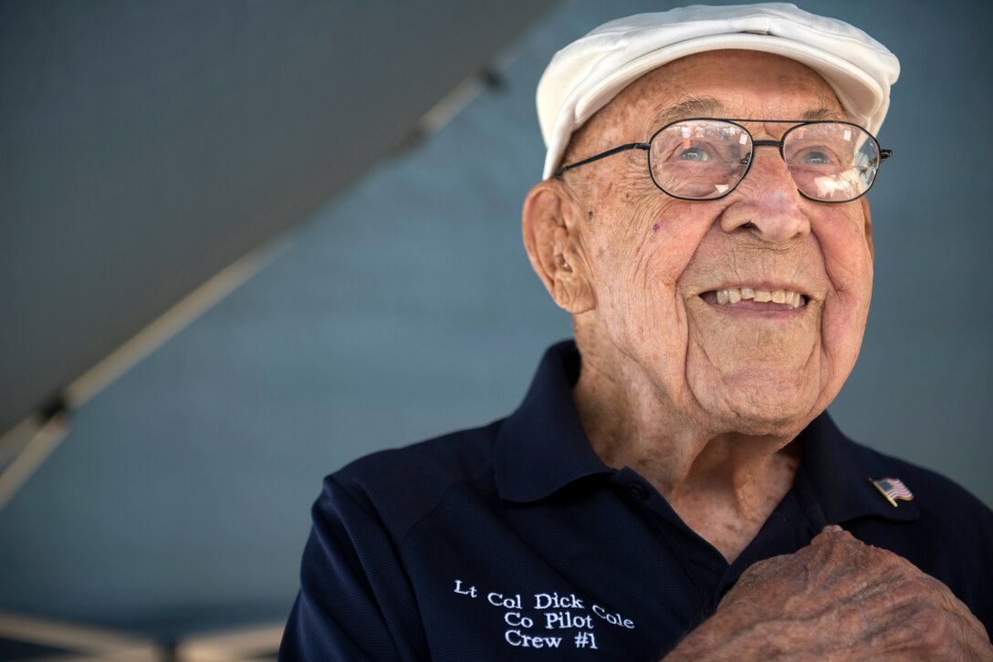 Retired Lt. Col. Richard E. Cole, copilot to Jimmy Doolittle during the Doolittle Raid, smiles as he honors the U.S. flag during the singing of the National Anthem at an airshow in Burnet, Texas. Cole was honored by the community and guests as the only remaining military service member alive from the April 18, 1942, Doolittle Raid. (U.S. Air Force photo by Staff Sgt. Vernon Young Jr.)