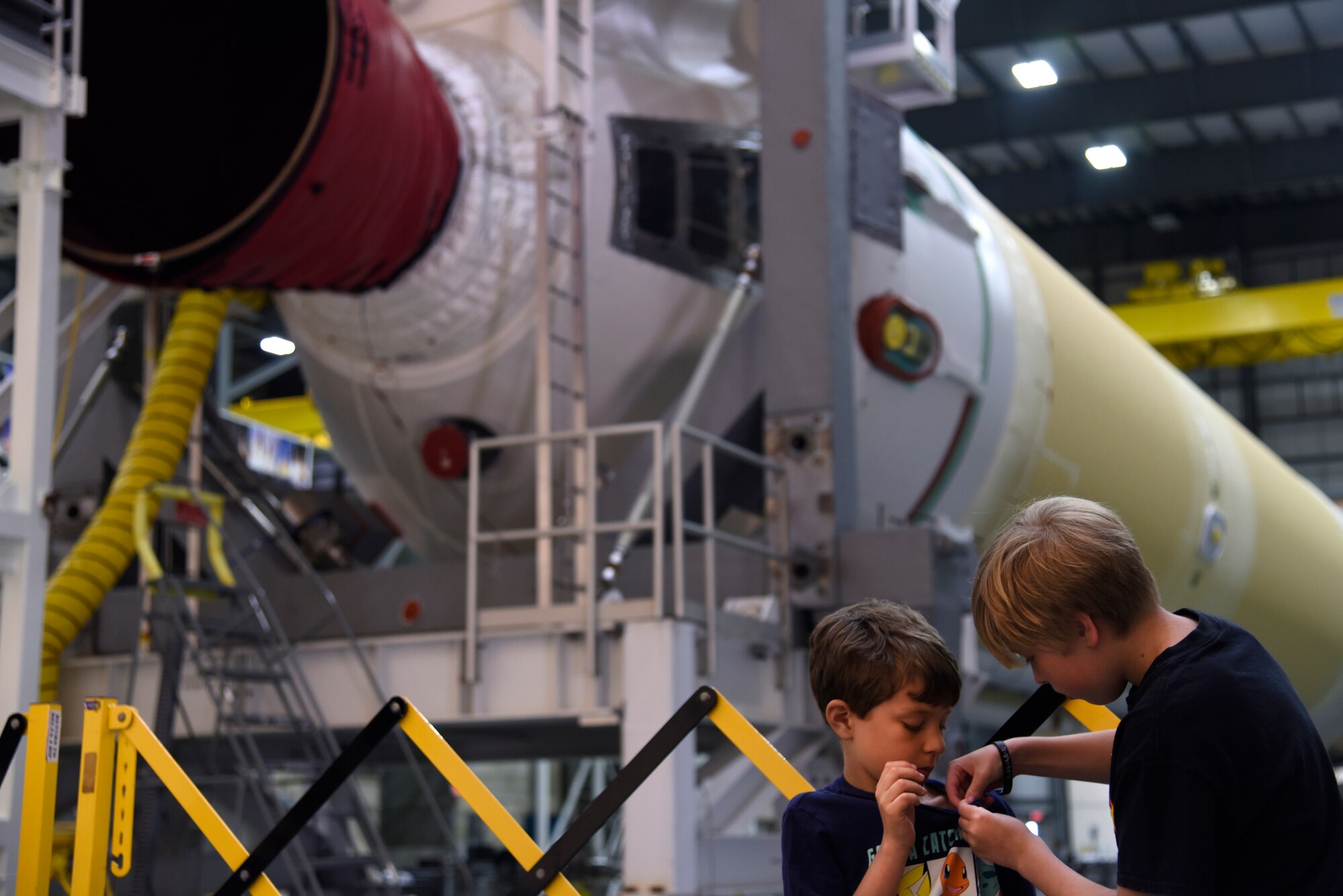 Chase and Seth pin on a minature rocket in front of United Launch Alliance’s Delta IV rocket booster during the 45th Space Wing Family Day self guided tour of Cape Canaveral Air Force Station, Fla. on April 6, 2019.
