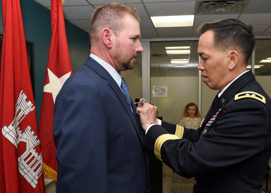 Maj. Gen. Mark Toy, U.S. Army Corps of Engineers Great Lakes and Ohio River Division commander, presents the Secretary of Defense Medal for the Defense of Freedom April 8, 2019 to Billy Johnson, recognizing the severe injuries he sustained while supporting a Corps of Engineers mission as a security officer in Iraq Dec. 9, 2007. The general presented the medal on behalf of Secretary of the Army Mark T. Esper during a ceremony held at the Tennessee Valley Authority Central Labs near Chickamauga Lock in Chattanooga, Tenn. (USACE photo by Lee Roberts)