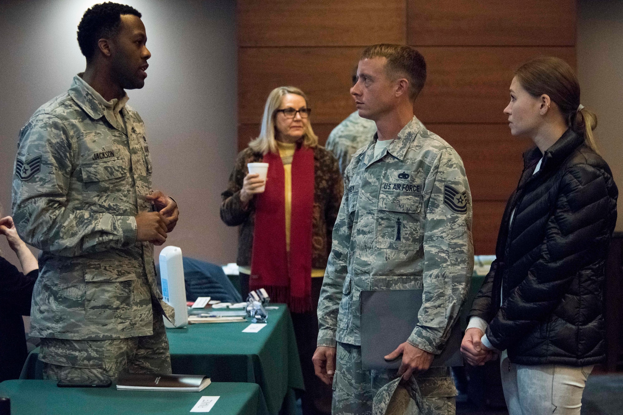 U.S. Air Force Staff Sgt. Terrence Jackson, a 673d Comptroller Squadron financial management specialist, speaks with Tech. Sgt. Justin Torrey, a 525th Aircraft Maintenance Squadron weapons load crew chief and his wife Olena Semyletko, during a welcome reception at Joint Base Elmendorf-Richardson, Alaska, April 8, 2019. The JBER Support to Tyndall Airmen and Families Reception was a one-stop information fair connecting them with the appropriate agencies to address their immediate and specific needs and to learn more about services they offer.