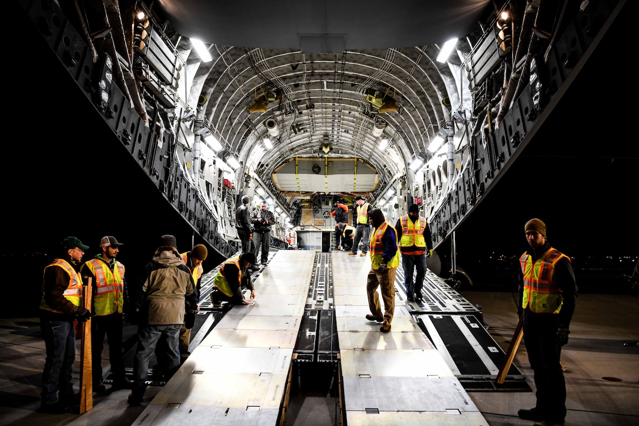 Men in transport jet’s cargo bay.