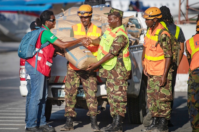 A soldier shakes hands with an aid worker.