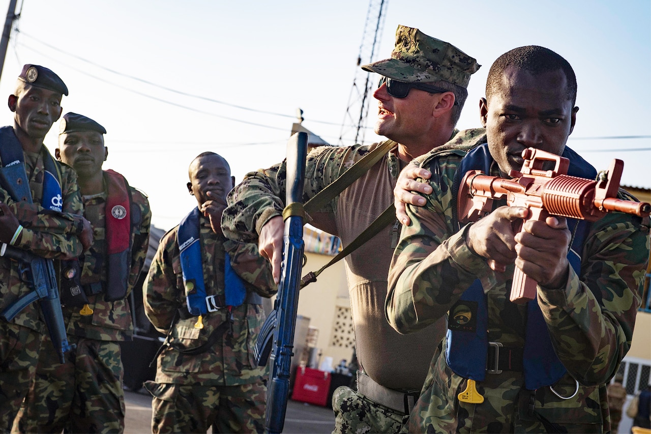 A Coast Guard member touches the shoulder of a Comorian soldier.