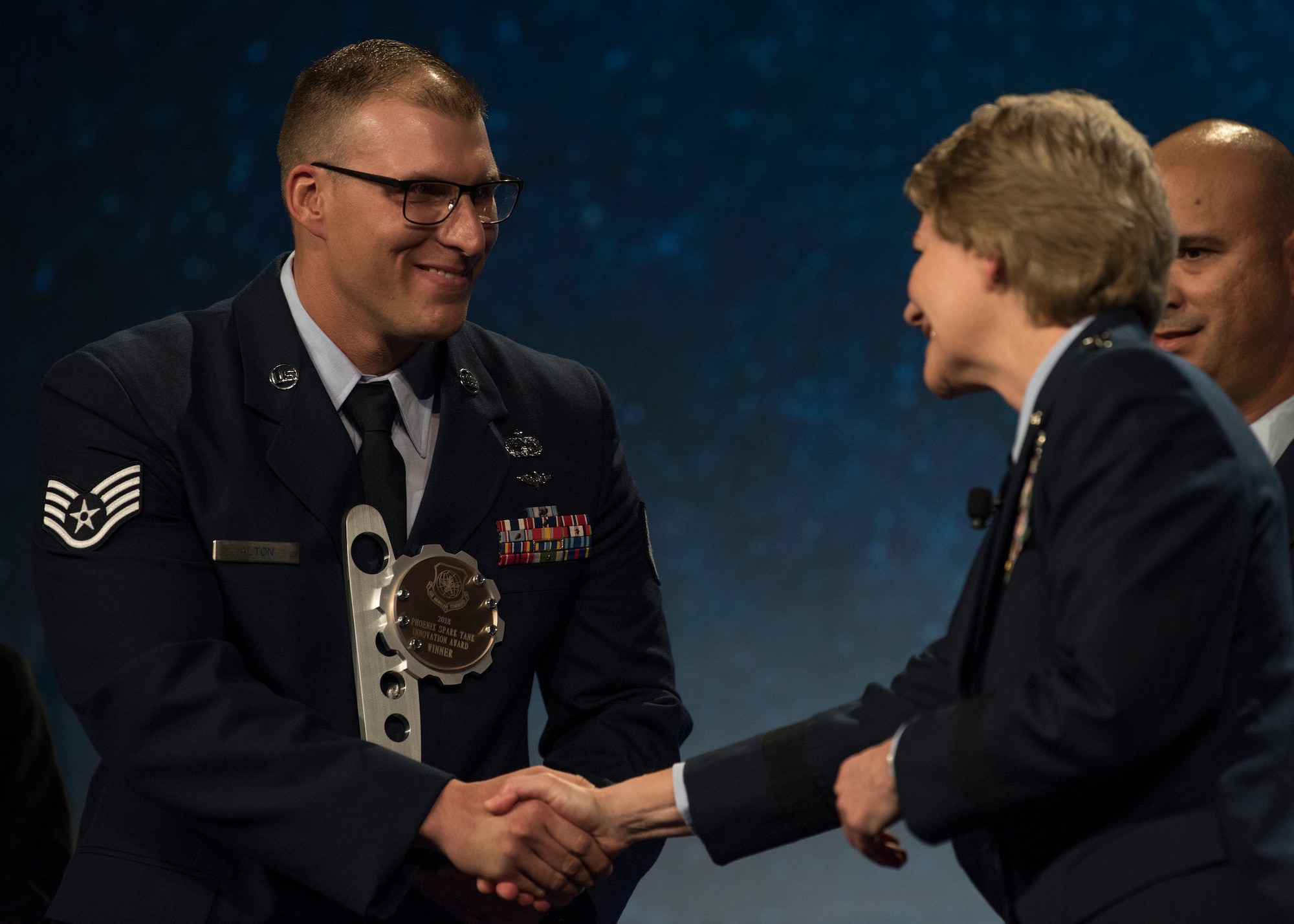 Gen. Maryanne Miller, Air Mobility Command commander, congratulates the winner of the 2018 AMC Phoenix Spark Tank competition, Staff Sgt. Travis Alton from the 19th Logistics Readiness Squadron, during the Airlift/Tanker Association Symposium in Grapevine, Texas, Oct. 27, 2018.