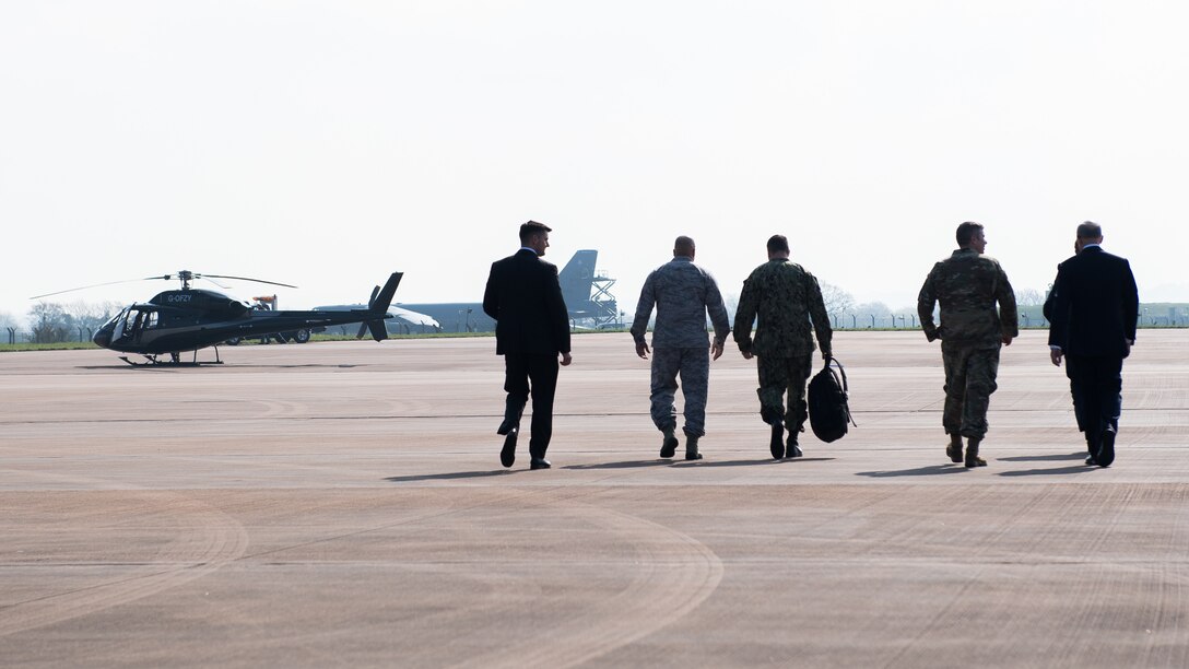 U.S. Ambassador to the U.K. Robert Wood Johnson and Rear Adm. David Manero, U.S. European Command Senior Defense Official are escorted back to their helicopter after their visit to RAF Fairford, England, March 29, 2019. Johnson and Manero visited the base during a U.S. Strategic Command Bomber Task Force in Europe and to celebrate the 70th anniversary of NATO. (U.S. Air Force photo by Airman 1st Class Tessa B. Corrick)