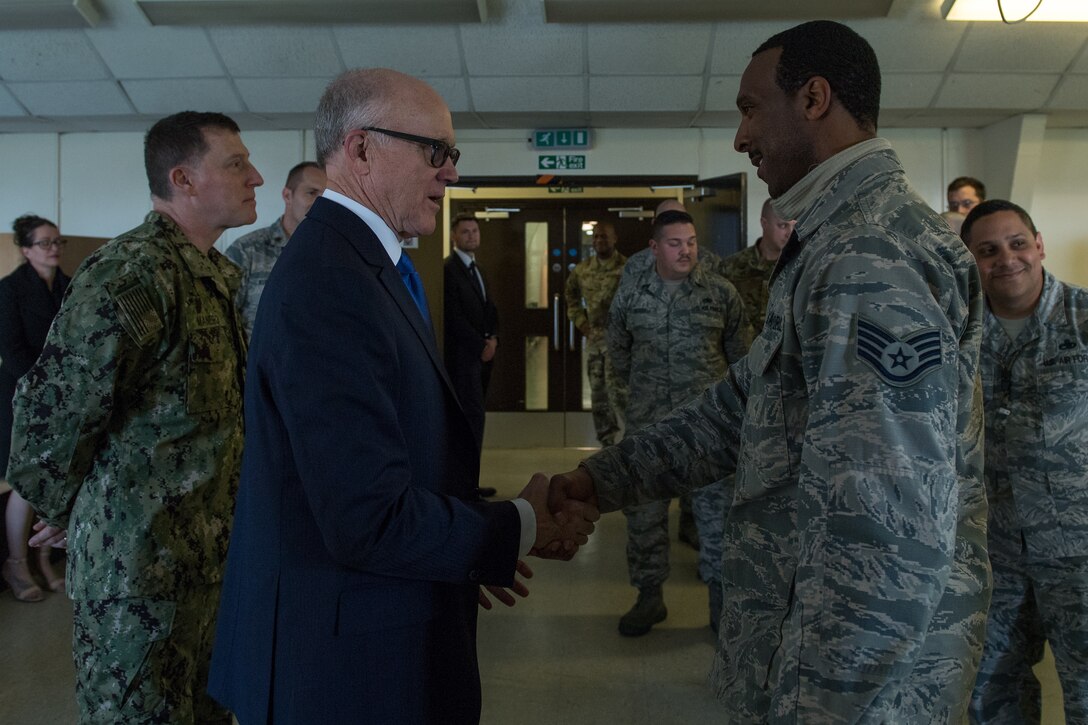 U.S. Ambassador to the U.K. Robert Wood Johnson (left), meets Staff Sgt. Randy Reynolds (right), 2nd Munitions Squadron munitions inspector deployed from Barksdale Air Force Base, La., during a visit to RAF Fairford, England, March 29, 2019. During his time at RAF Fairford, Johnson visited the maintenance building to meet and talk with some of the Airmen that are temporarily working there in support of U.S. Strategic Command’s Bomber Task Force in Europe. (U.S. Air Force photo by Airman 1st Class Tessa B. Corrick)