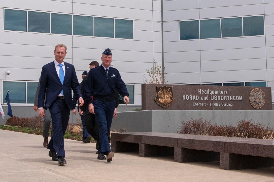 Two defense leaders walk next to each other.