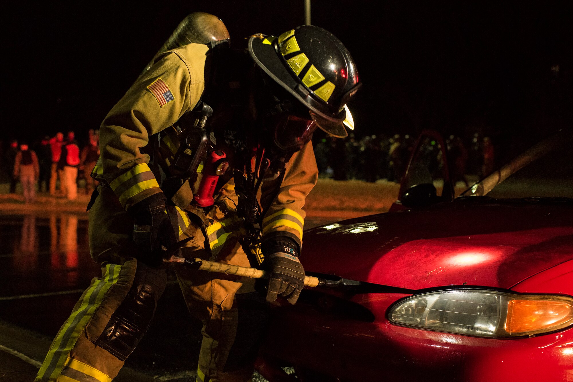 A firefighter assigned to Little Rock Air Force Base, Arkansas, practices dousing a car fire during Operation Phalax held March 30-31, 2019.  The operation is a joint exercise hosted by the Arkansas National Guard for civil and military organizations to train their members in tactics and techniques used in responding to a civil disturbance. (U.S. Air National Guard photo by Staff Sgt. Matthew Matlock)