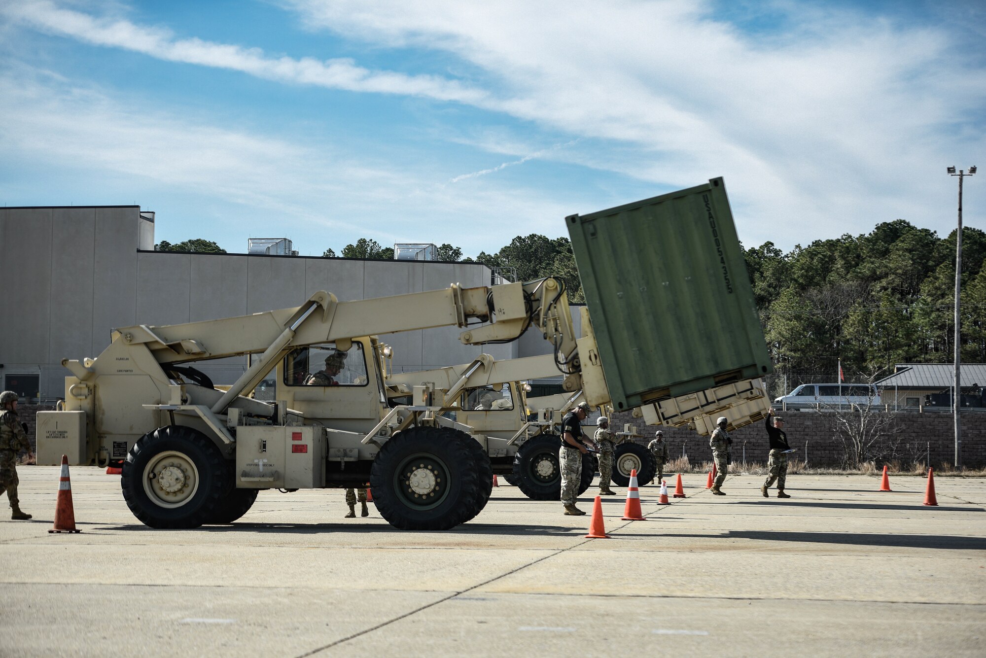 U.S. Army Soldiers assigned to the 7th Transportation Brigade (Expeditionary), prepare to compete in navigating a 5K forklift through an “S-pattern” obstacle course at Joint Expeditionary Base Little Creek-Fort Story, Virginia, March 29, 2019. Due to restricted visibility, the forklift driver relies on the direction of his ground guide to navigate.  (U.S. Army photo by Spc. Travis Teate)
