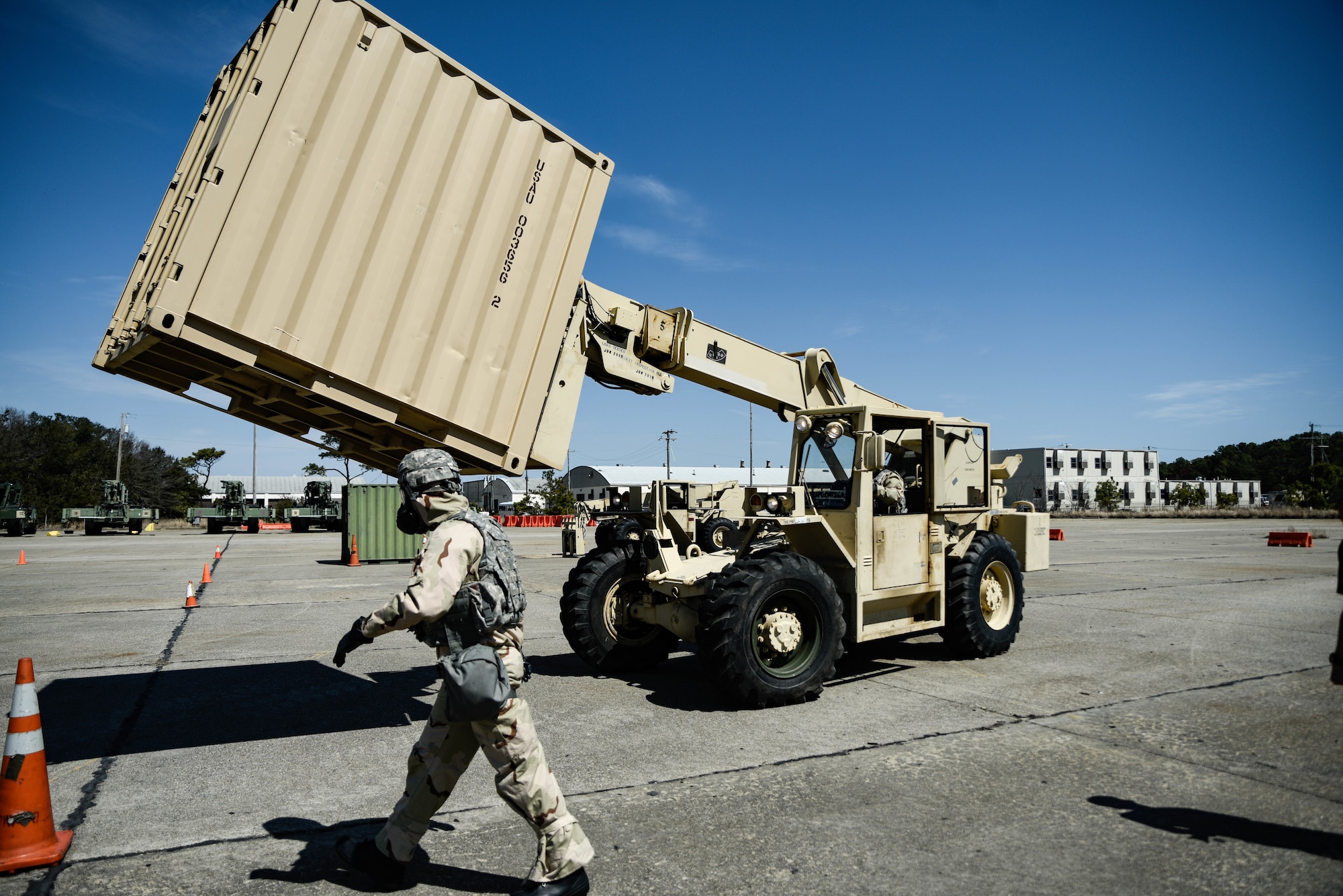 U.S. Army Soldiers assigned to the 10th Transportation Battalion, 7th Trans. Brigade (Expeditionary), navigate a course with a Kalmar 5k forklift at Joint Expeditionary Base Little Creek-Fort Story, Virginia, March 29, 2019. The whole competition was done in mission-oriented protective posture level 4 gear. (U.S. Army photo by Spc. Travis Teate)