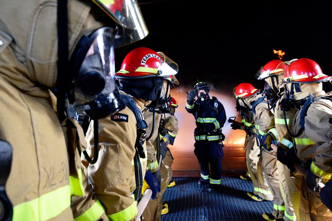 Sailors put out a fire during firefighting training.