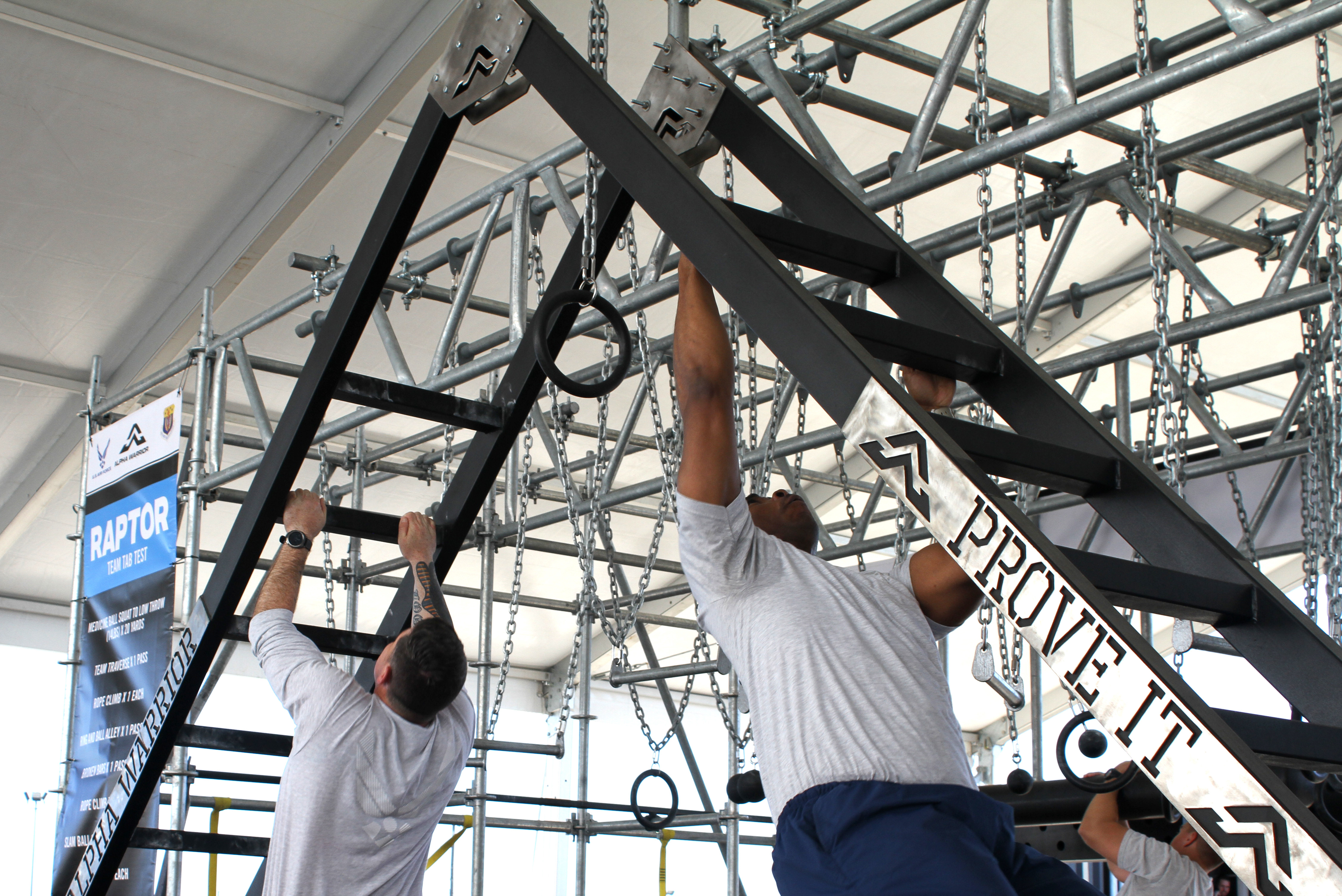 Two members of the Air Force Services Activity demonstrate one of nine stations on an Alpha Warrior Battle Rig during Industry Day April 9, 2019, on Joint Base San Antonio-Lackland, Texas. For many visiting senior Air Force leaders, this was the first time they’d had the opportunity to see up-close the various ways the equipment helps to build ready and resilient Airmen. In addition to the adult rig, a new youth rig that will be rolled out to 10 installations later this year was also on display and demonstrated by JBSA youth. (U.S. Air Force photo by Debbie Aragon)