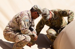 Warrant Officer Joseph Pina, 504th Quartermaster Company, 524th Support Battalion, 300th Sustainment Brigade,discusses fuel bag operations with Staff Sgt. Robert Miranda, 300th Sustainment Brigade fuel operation noncommissioned officer, at Camp Buehring, Kuwait, March 19, 2019.