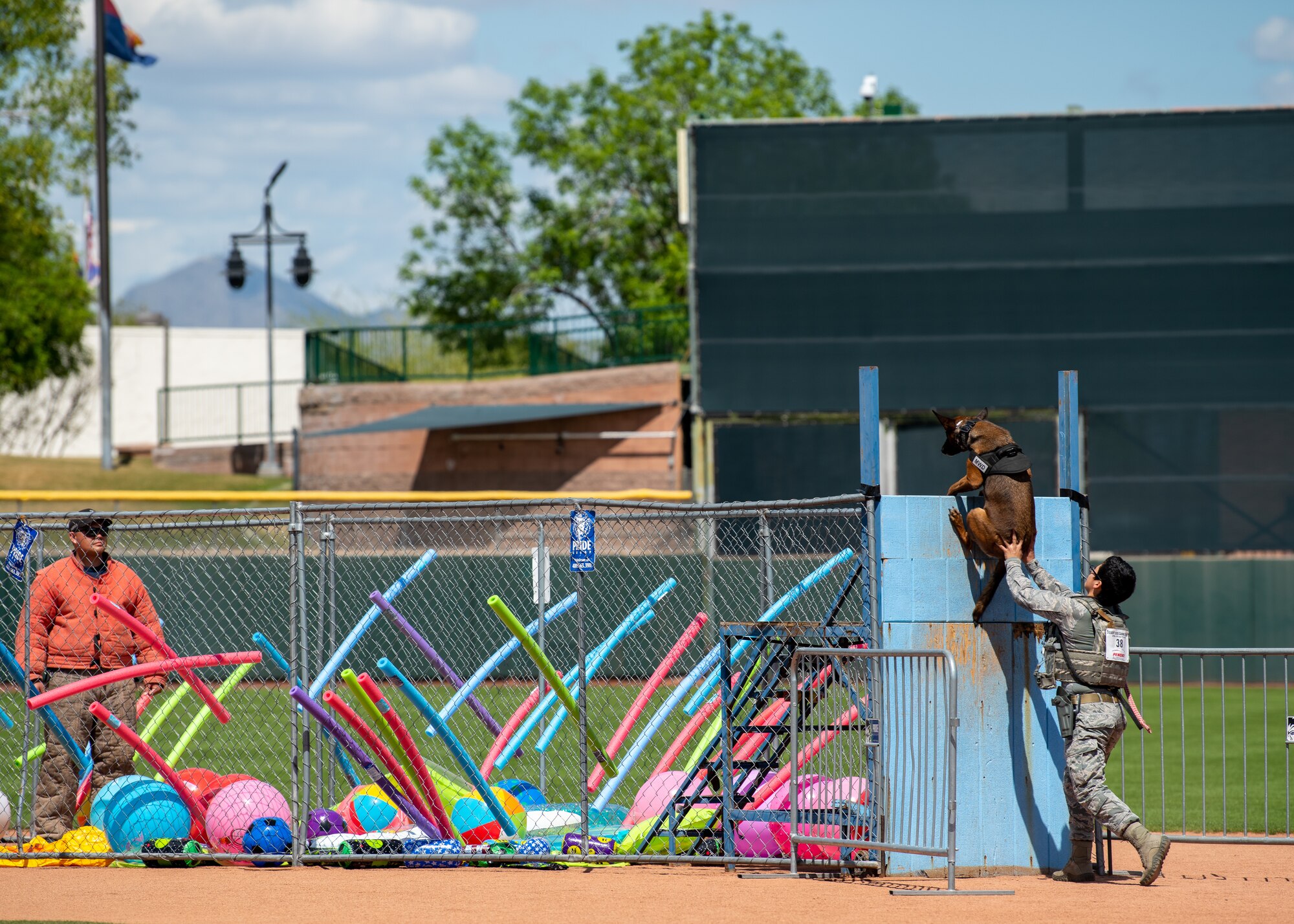Staff Sgt. Elizabeth Pedroza, 56th Security Forces Squadron military working dog handler, pushes Frida, her MWD, over a six-foot wall during the 2019 Desert Dog Trials, April 6, at Scottsdale Stadium, Scottsdale, Ariz.