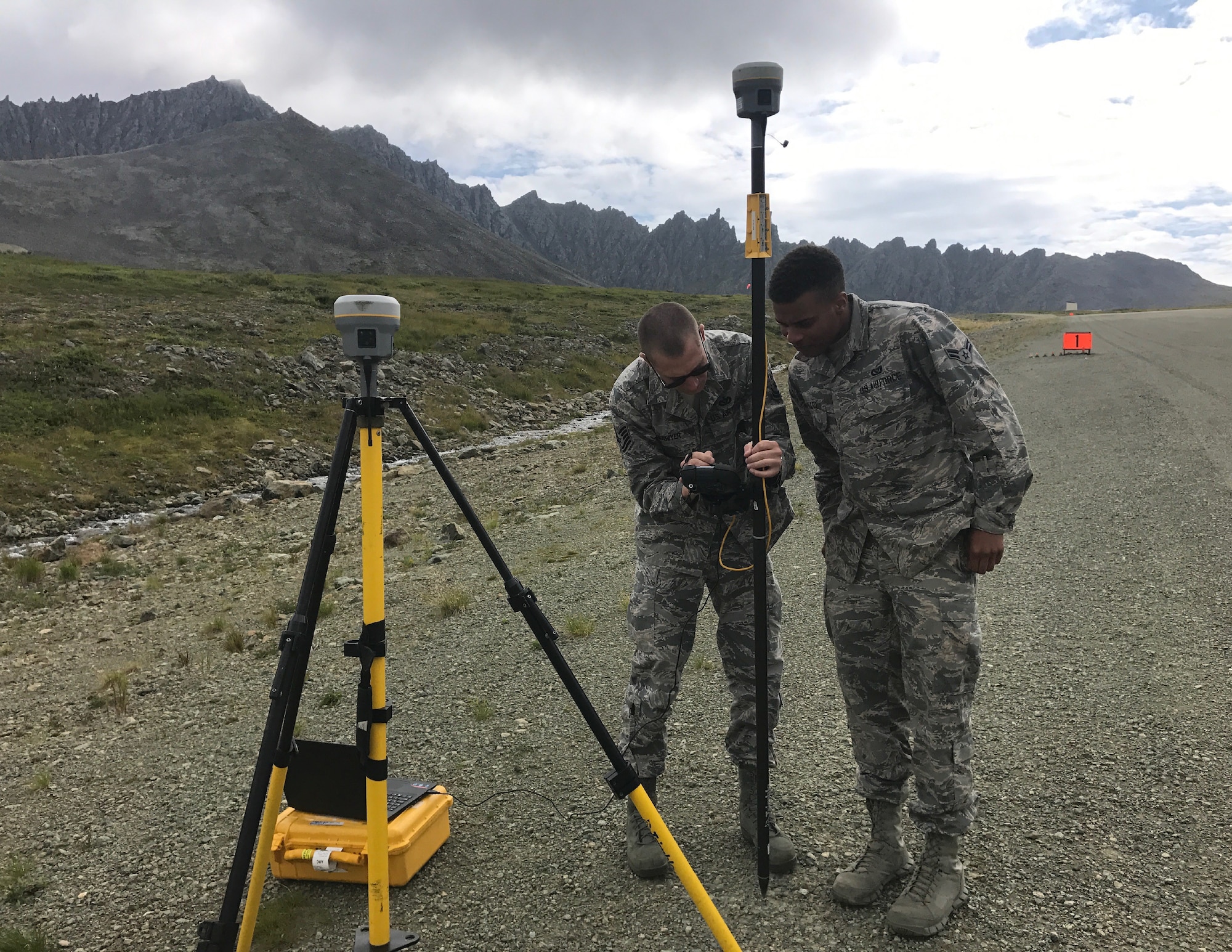 U.S. Air Force Tech. Sgt. James Lawyer, 611th Civil Engineer Squadron airfield planning noncommissioned officer in charge, and Airman 1st Class Shane Leapheart, 673d CES engineer, set up a temporary base station at Cape Newnham, Alaska, August 2017. This procedure locates benchmarks on the site to establish vertical and horizontal coordinates for future projects and property surveying.