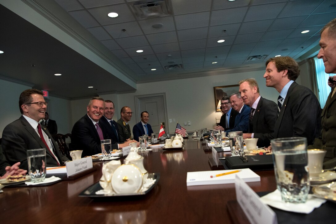 Acting Defense Secretary Patrick M. Shanahan sits at at table with a group of people.
