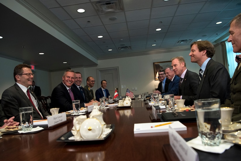 Acting Defense Secretary Patrick M. Shanahan sits at at table with a group of people.