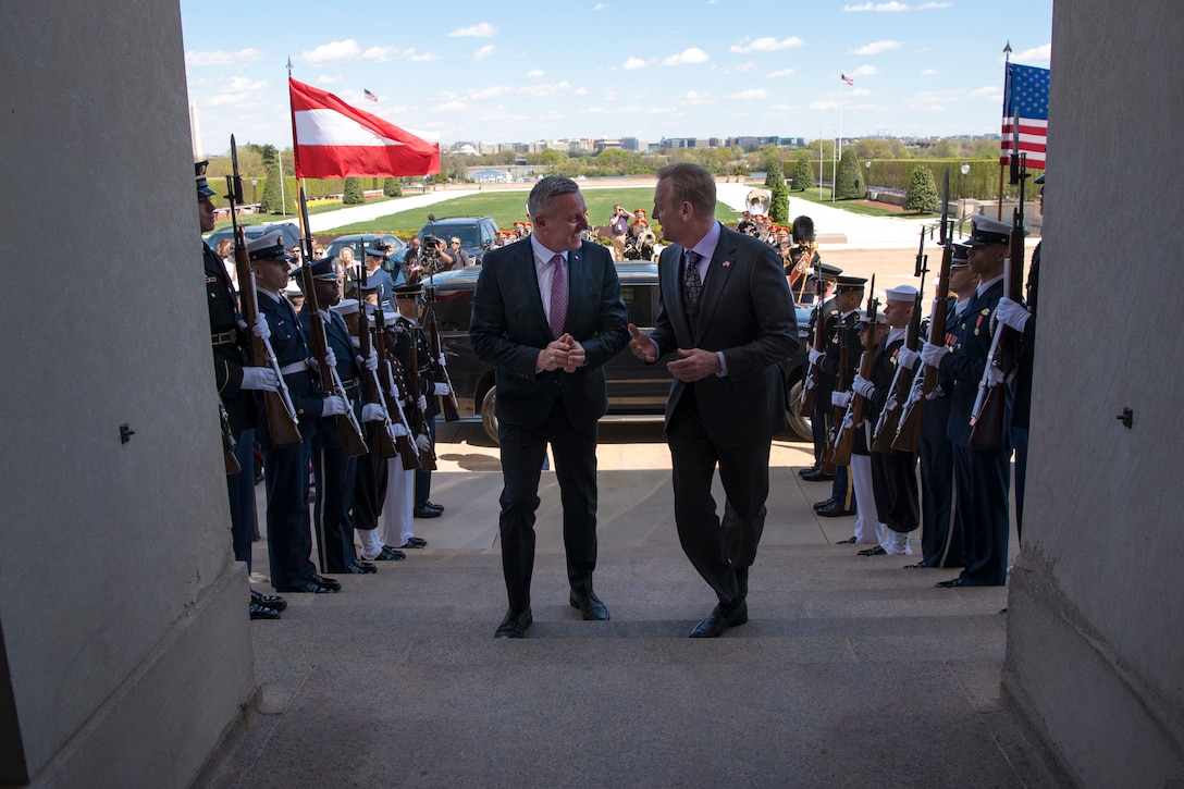 Acting Defense Secretary Patrick M. Shanahan walks up steps with the Austrian defense minister; service members stand on either side.