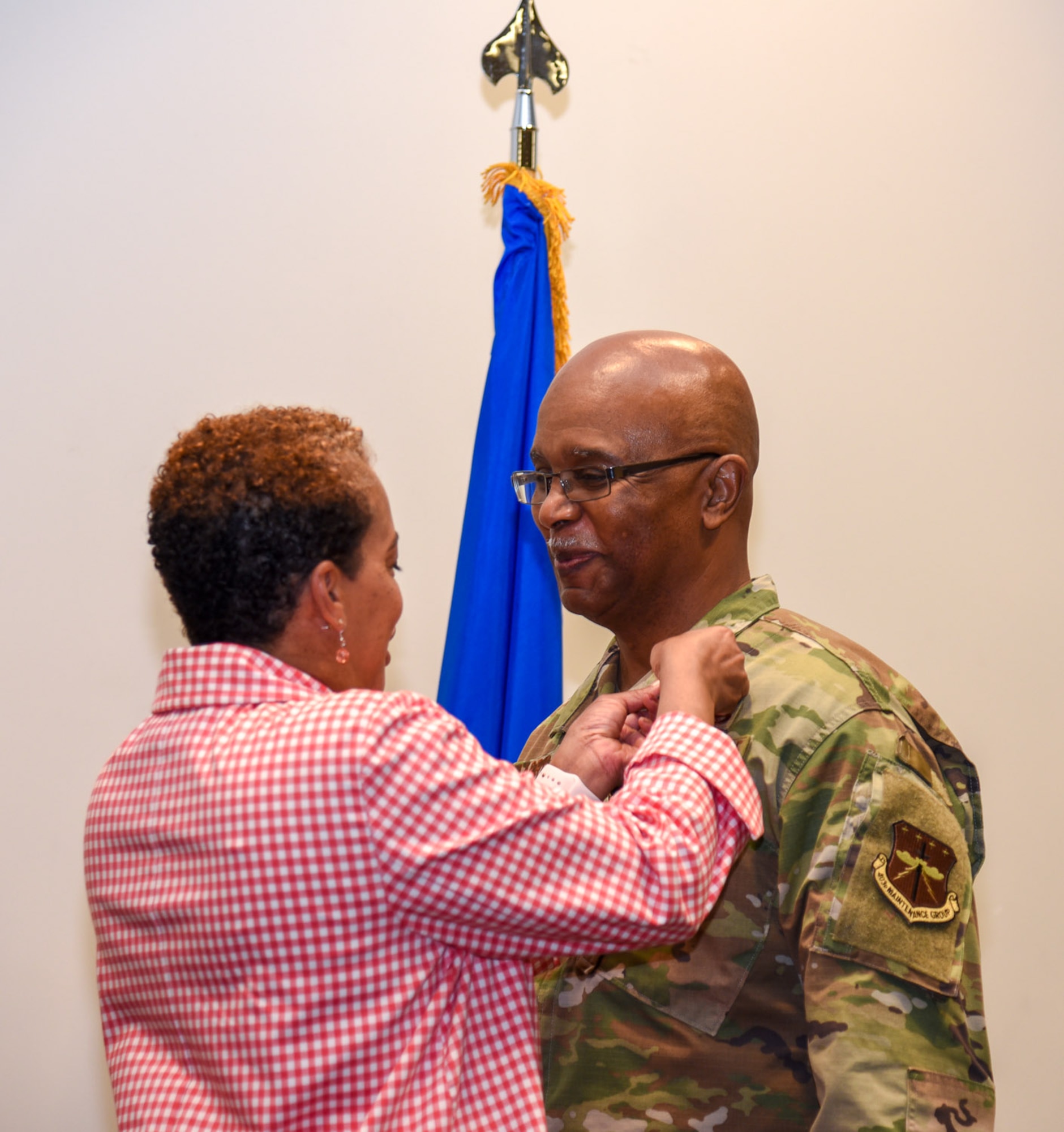Chief Master Sgt. Marshall O. Harris, Jr., 403rd Maintenance Group quality assurance superintendent, stands as his wife Sharon pins a medal to his lapel during his retirement ceremony April 6, 2019 at the Roberts Maintenance Facility here. Harris said he has the support of his wife to thank for getting him through his Air Force career. (U.S. Air Force photo by Senior Airman Kristen Pittman)