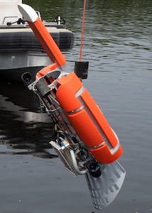 The Airborne Surface Quad Thruster Interface Device, or ASQUID, attaches to the side of a MH-60 helicopter and allows the crew to lowers a MK-18 into the water to search for mines preventing Navy personnel from having to enter a minefield.