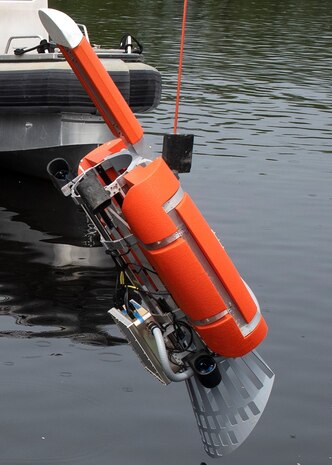 The Airborne Surface Quad Thruster Interface Device, or ASQUID, attaches to the side of a MH-60 helicopter and allows the crew to lowers a MK-18 into the water to search for mines preventing Navy personnel from having to enter a minefield.