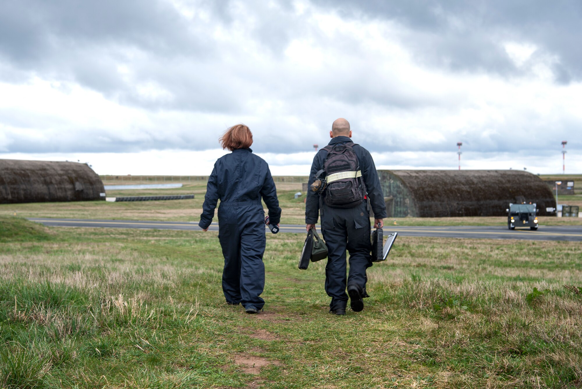 U.S. Air Force Staff Sgt. Stephanie Gillie, 52nd Security Forces Squadron investigator, left, and Senior Airman Jose Pagan, 52nd Aircraft Maintenance Squadron assistant dedicated crew chief, right, walk to the flightline at Spangdahlem Air Base, Germany, April 3, 2019. Gillie shadowed Pagan as part of the 52nd AMXS Crew Chief for a Day program. (U.S. Air Force photo by Airman 1st Class Valerie Seelye)