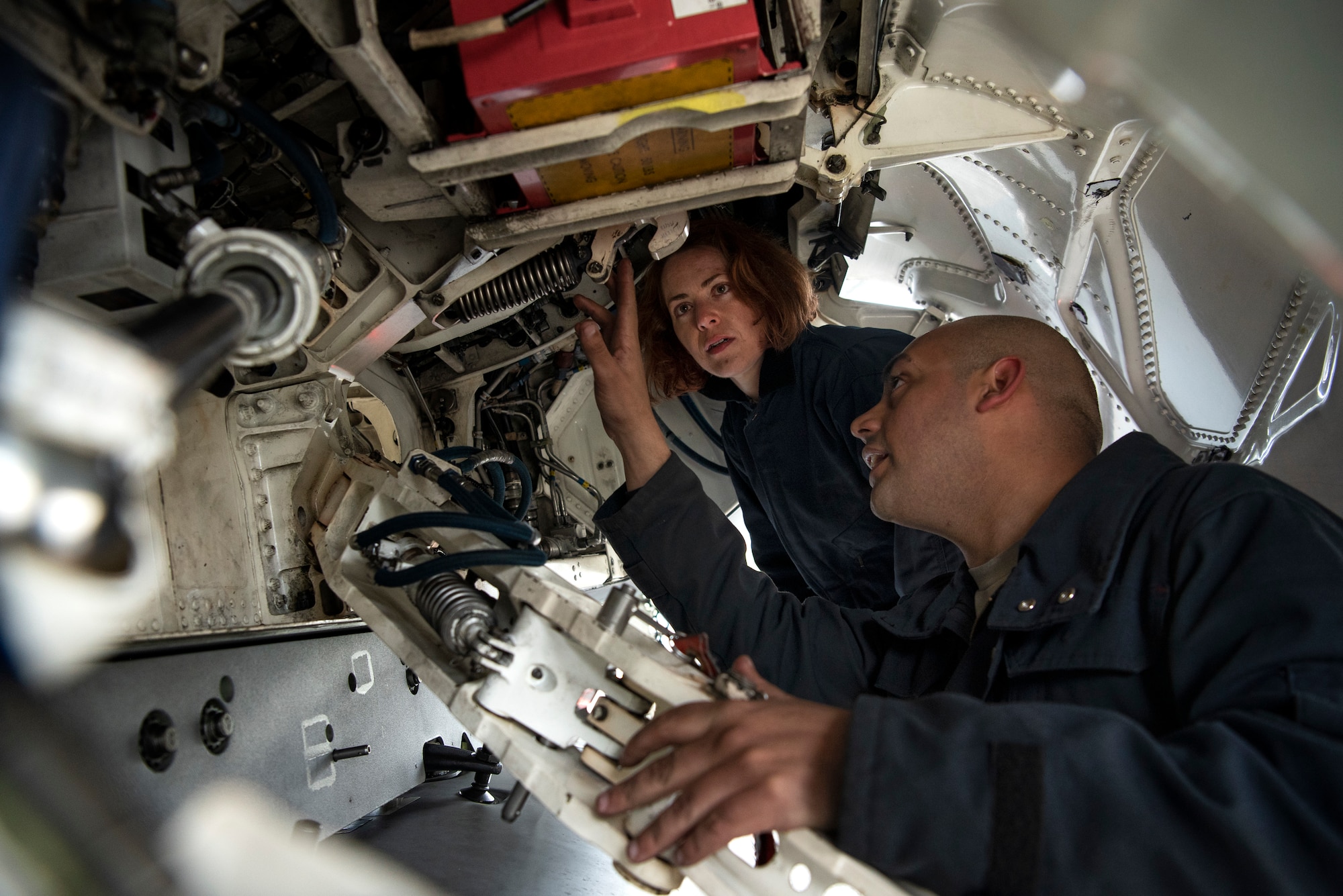U.S. Air Force Staff Sgt. Stephanie Gillie, 52nd Security Forces Squadron investigator, center, learns how to inspect an aircraft from Senior Airman Jose Pagan, 52nd Aircraft Maintenance Squadron assistant dedicated crew chief, right, at Spangdahlem Air Base, Germany, April 3, 2019. The AMXS Crew Chief for a Day program allows Airmen to experience flightline operations. Gillie, who had never been on a flightline before, participated to gain a better understanding of the work maintainers perform. (U.S. Air Force photo by Airman 1st Class Valerie Seelye)