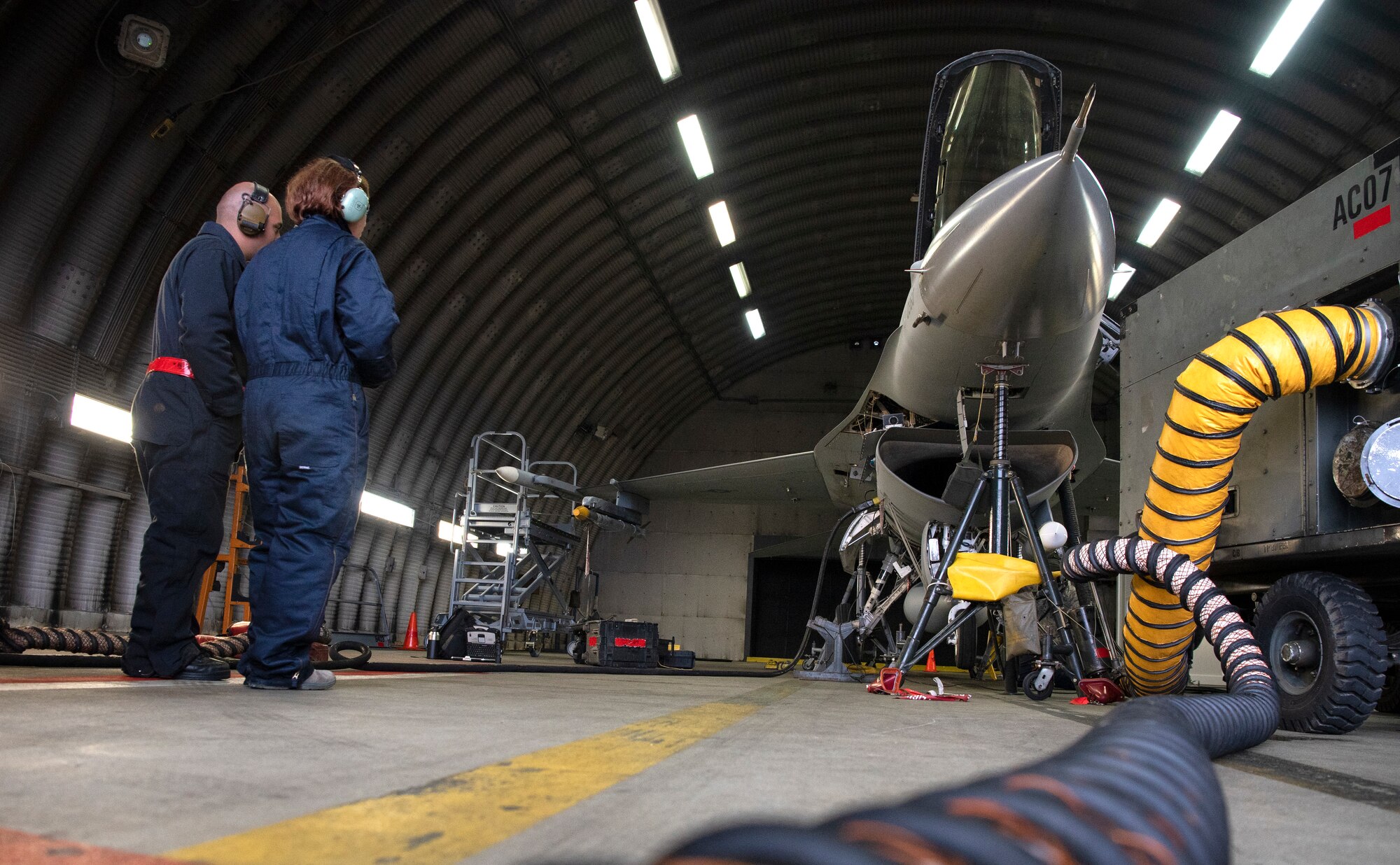 U.S. Air Force Staff Sgt. Stephanie Gillie, 52nd Security Forces Squadron investigator, right, and Senior Airman Jose Pagan, 52nd Aircraft Maintenance Squadron assistant dedicated crew chief, left, observe a F-16 Fighting Falcon landing gear inspection at Spangdahlem Air Base, Germany, April 3, 2019. Gillie's participation was part of the 52nd AMXS Crew Chief for a Day program. The program gives Airmen that don't work on the flightline a bigger picture of the 52nd Fighter Wing mission. (U.S. Air Force photo by Airman 1st Class Valerie Seelye)