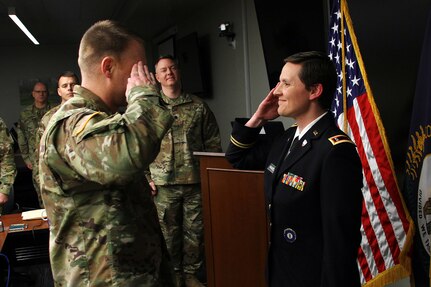 Newly appointed Warrant Officer Natalie Wamsley salutes her husband, Chief Warrant Officer Ronald Wamsley, during a commissioning ceremony in Frankfort, Ky., March 19, 2019. Wamsley completed warrant officer candidate school March 1 while battling cancer.