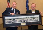 Col. Terry McClain, 433rd Airlift Wing commander, is presented with a vintage 433rd Military Airlift Wing panoramic photo from 1991 by Steve Richmond, an honorary commander alumni and president of Pizza Hut of San Antonio, April 6 at a northwest San Antonio hotel. Seventeen honorary commanders were inducted at the annual event.