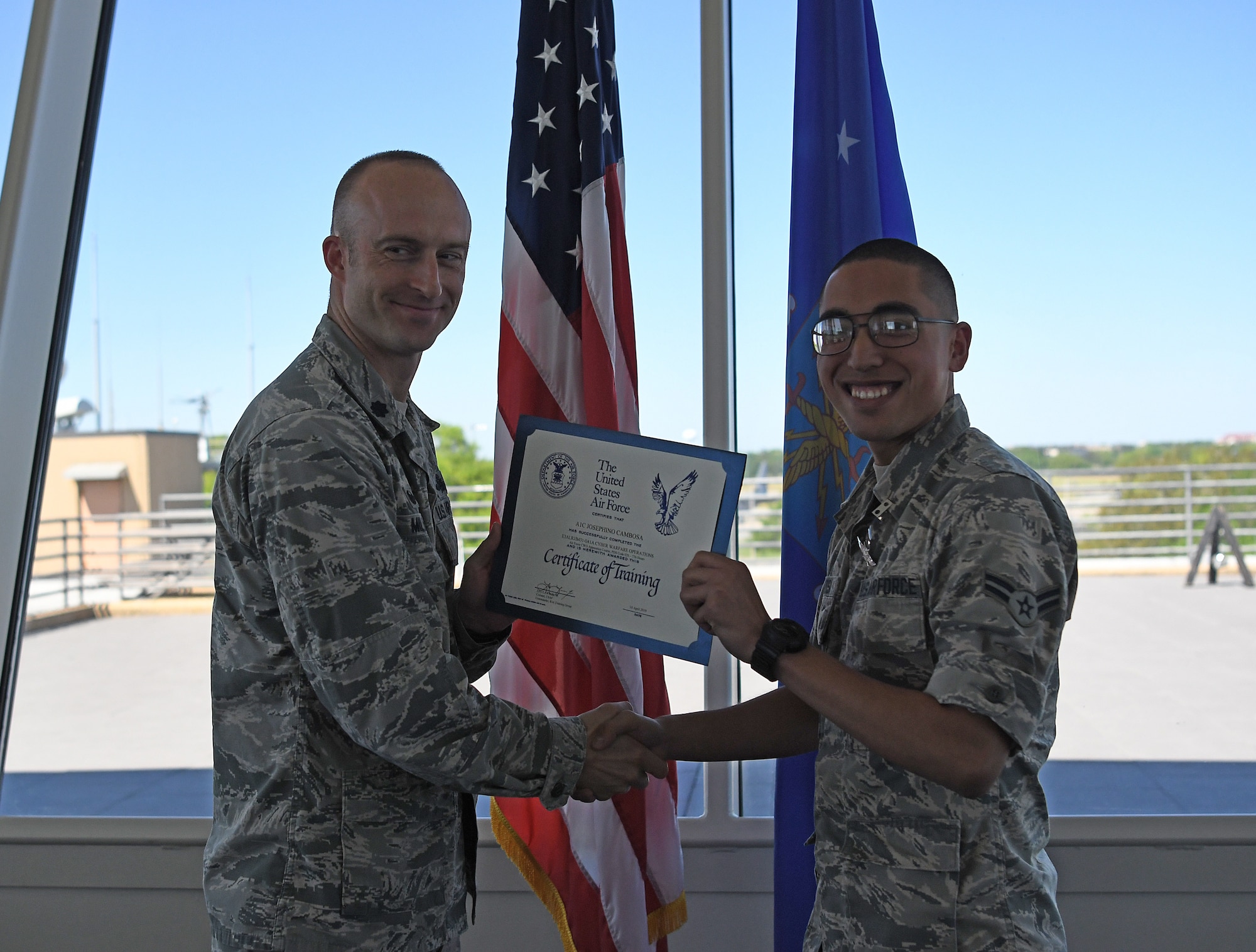 Lt. Col. Andrew Miller, 333rd Training Squadron commander, awards Airman 1st Class Josephino Cambosa, 333rd TRS student, a certificate of training for completing the Cyber Warfare Operations course on Keesler Air Force Base, Mississippi, April 10, 2019. Cambosa is the first non-prior service Airman to graduate from the Cyber Warfare Operations school house. (U.S. Air Force photo by 2nd Lt. Anh T. Bui)