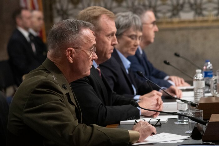 Men sit before Senate microphones.