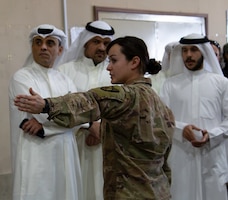 1st Lt. Stephanie Palamas, 502th Human Resource Company, 300th Sustainment Brigade, discusses operations at the Joint Military Mail Terminal with the Kuwait Criminal Investigation Division at Camp Arifjan, Kuwait, March 7, 2019.