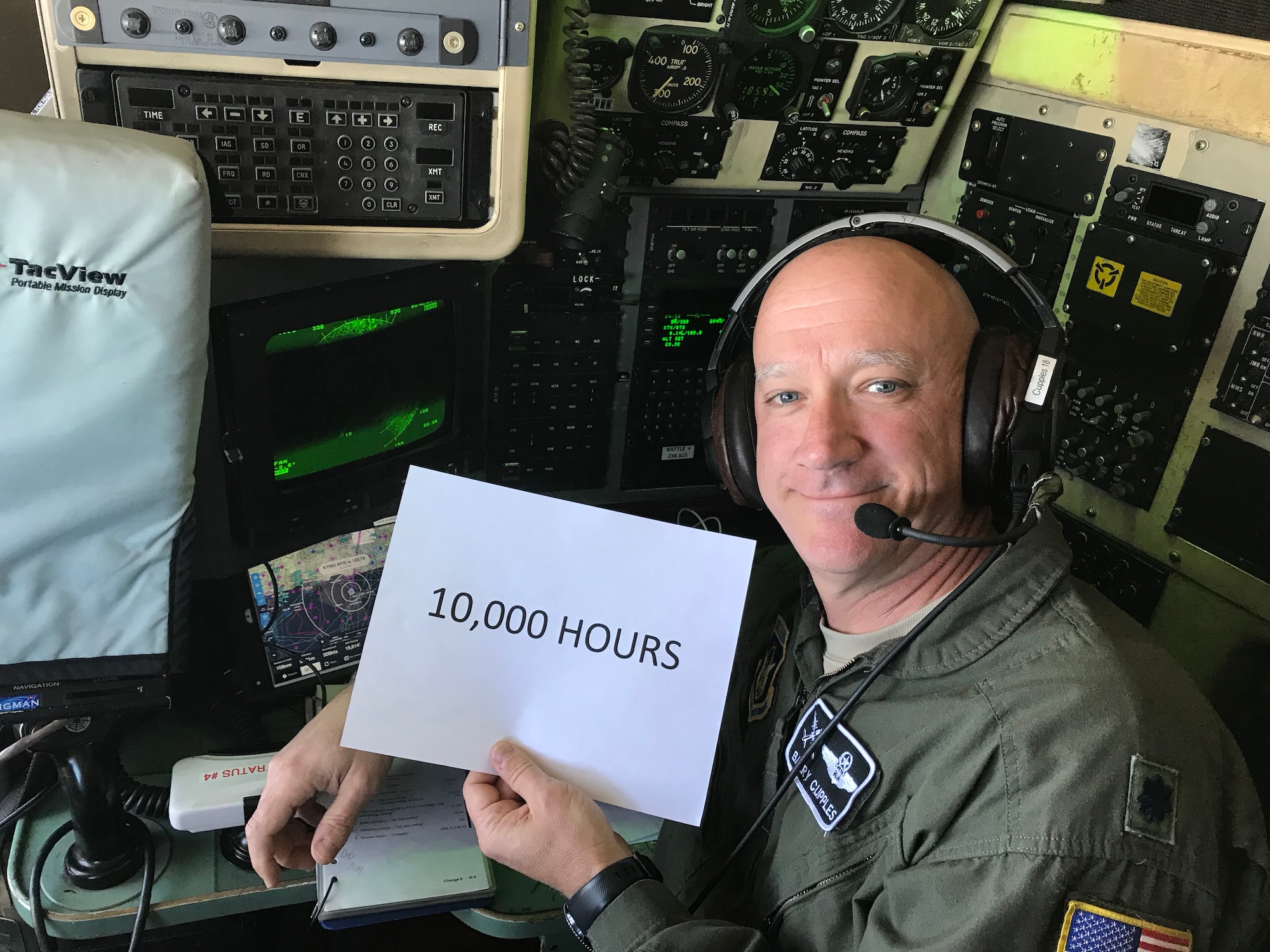 Lt. Col. Barry “JR” Cupples, a navigator with the 757th Airlift Squadron, holds a 10,000 hours sign in the flight deck of a C-130H Hercules aircraft for a photo at the exact moment he completed his ten thousandth C-130 flight hour.