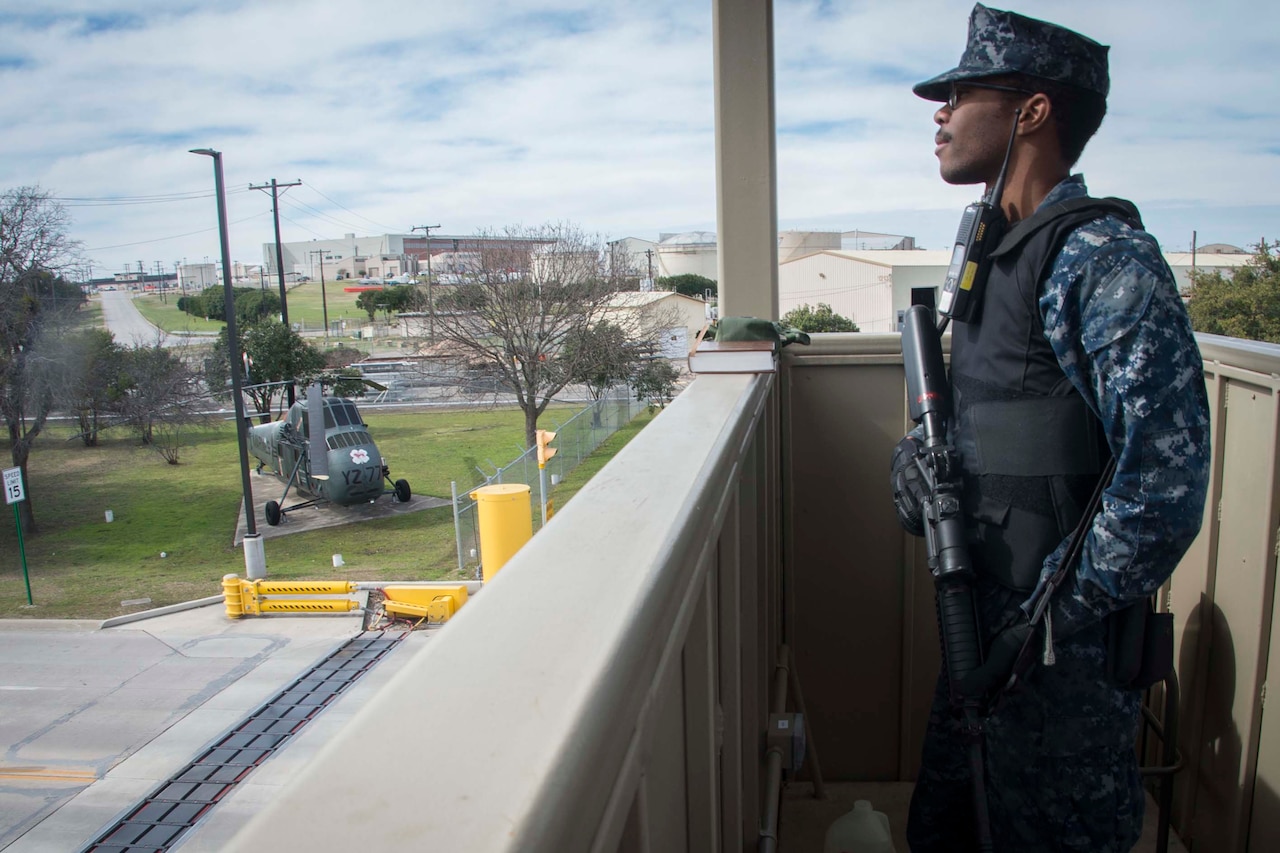 A sailor stands guard in a tower.