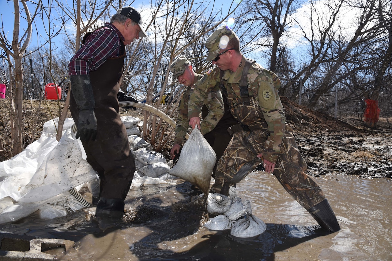 Service members build sand bags.