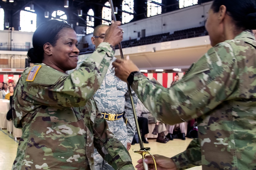 Command Sgt. Maj. Perlisa Wilson, left, the Maryland National Guard's senior enlisted leader, accepts the noncommissioned officer's saber from Army Maj. Gen. Linda Singh, the adjutant general of the Maryland Guard, during a ceremony at the Fifth Regiment Armory in Baltimore, Md., where Wilson formally took on the duties of her position, Dec. 8, 2018.