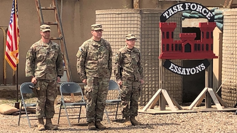 Capt. Joe Marut, Col. Jim Riely and Capt. Andrea Taylor stand at attention during a Change of Command Ceremony at Camp Taji, Iraq, April 6, 2019. Marut relinquished command of the Task Force Essayons (TFE) Headquarters Detachment to Taylor. Riely, the TFE commander, presided over the ceremony.