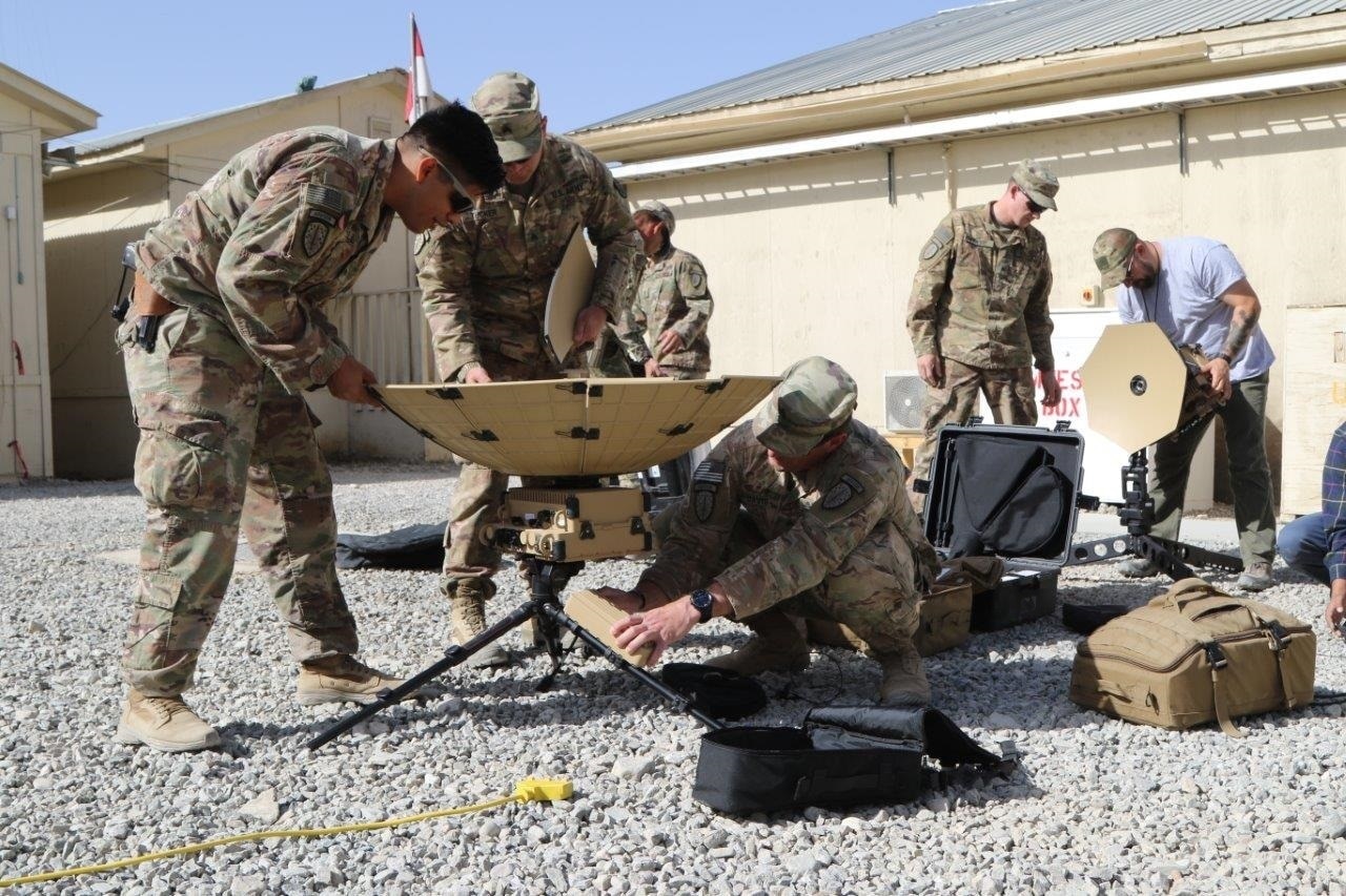 Service members train with satellite communication equipment.