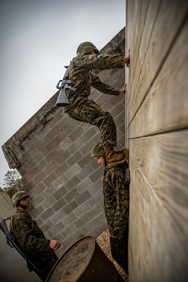 A Naval Reserve Officers Training Corps Midshipmen from Tulane University and Southern University and A&M College, climbs a wall during a leadership reaction course at Camp Shelby in Hattiesburg, Miss., April 6, 2019. Marines with Marine Forces Reserve assisted in the LRCs to provide experience and insight for midshipmen to better prepare them for Officer Candidate School and for their future military careers. (U.S. Marine Corps photo by Sgt. Andy O. Martinez)