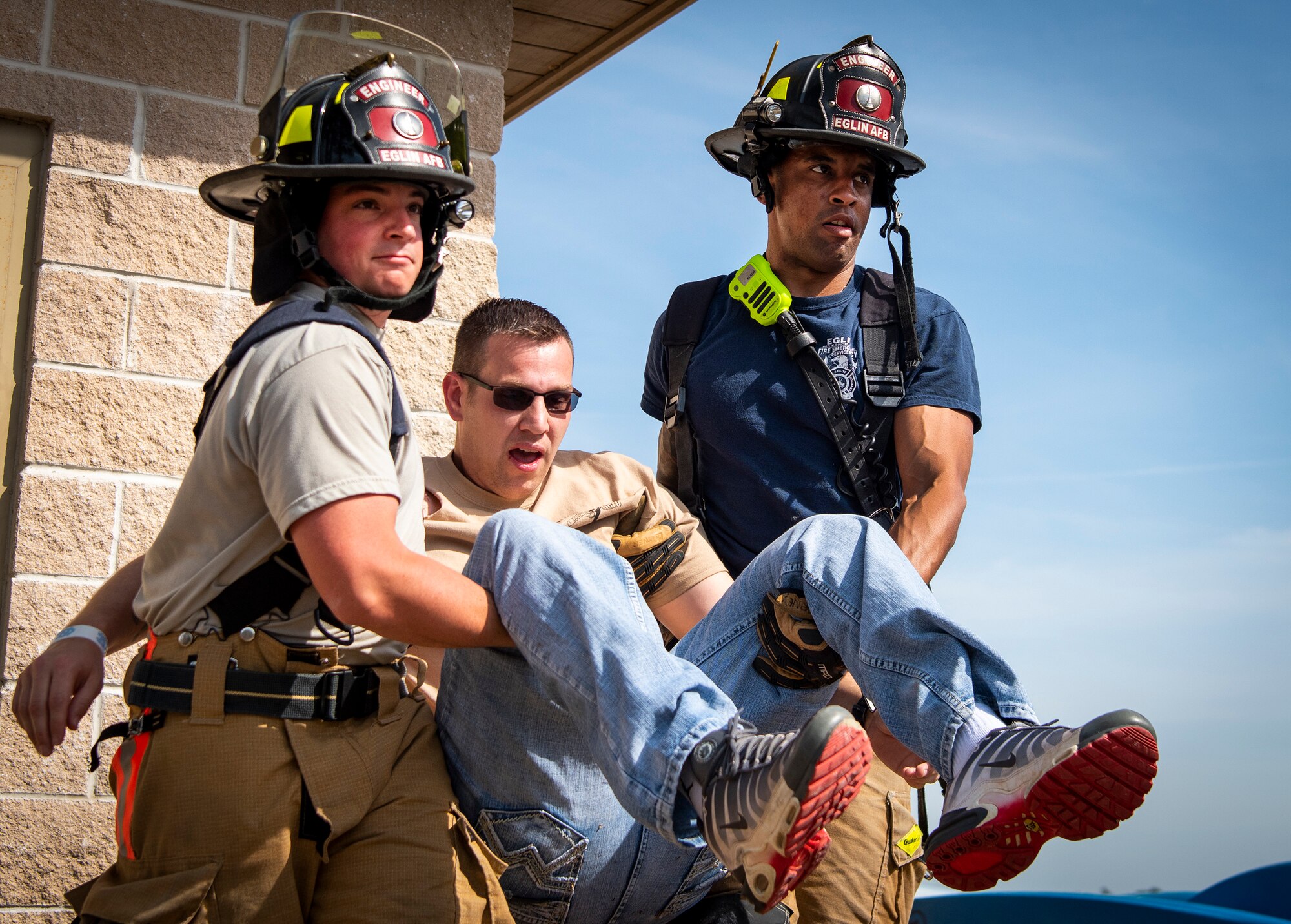 Firefighters carry a simulated explosion victim to safety during an exercise