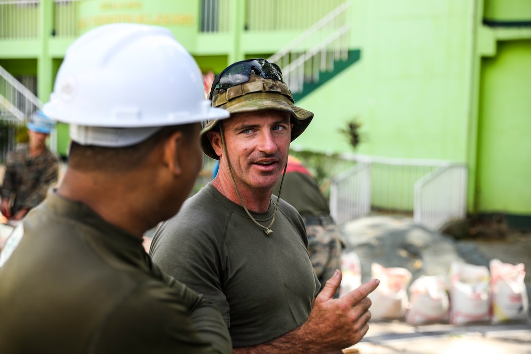 Australian Army Pvt. James McLennan discusses operations with Philippine Army Capt. Alger Depositario, the project officer, at Victor O' De Guia Jr. Memorial Elementary School in Balian, Pangil, Laguna, Philippines, March 27, 2019, as part of Exercise Balikatan.