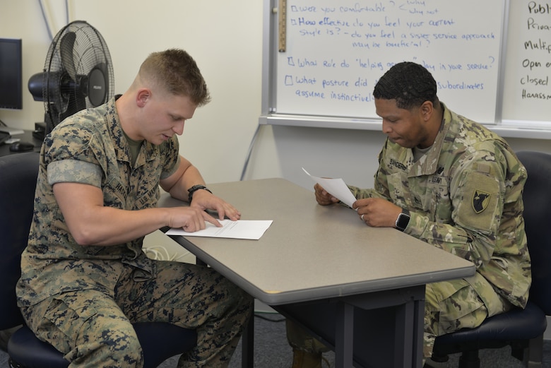 Two service members discuss best counseling procedures during the Okinawa Joint PME Experience April 1, 2019, at Kadena Air Base, Japan. With the military becoming more and more integrated in order to ensure mission success, leaders at every level must know and be comfortable operating in a joint environment. (U.S. Air Force photo by Staff Sgt. Benjamin Sutton)