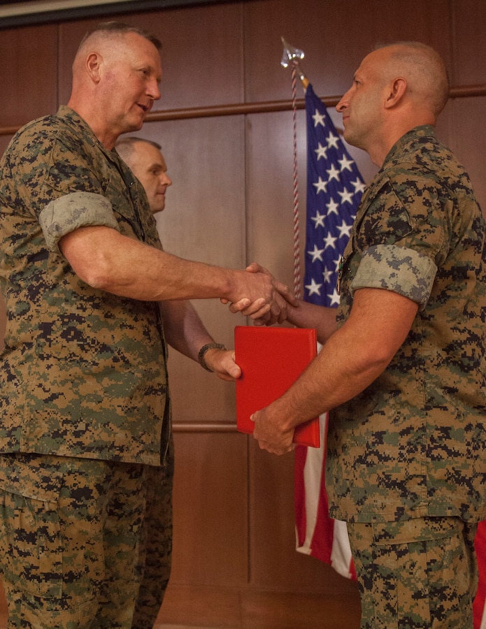 Maj. John C. Johnson, right, an avionics officer with 4th Marine Aircraft Wing, shakes hands with Maj. Gen. Bradley S. James, left, commander of Marine Forces Reserve and Marine Forces North, after being awarded the Navy and Marine Corps Achievement Medal with a Gold Star in lieu of 5th award at the Marine Corps Support Facility New Orleans, April 11, 2019. Johnson was awarded the medal for lifesaving actions in the Savannah International Airport when he noticed a man with heart attack symptoms and performed CPR until paramedics arrived. (U.S. Marine Corps photo by Lance Cpl. Preston L. Morris)