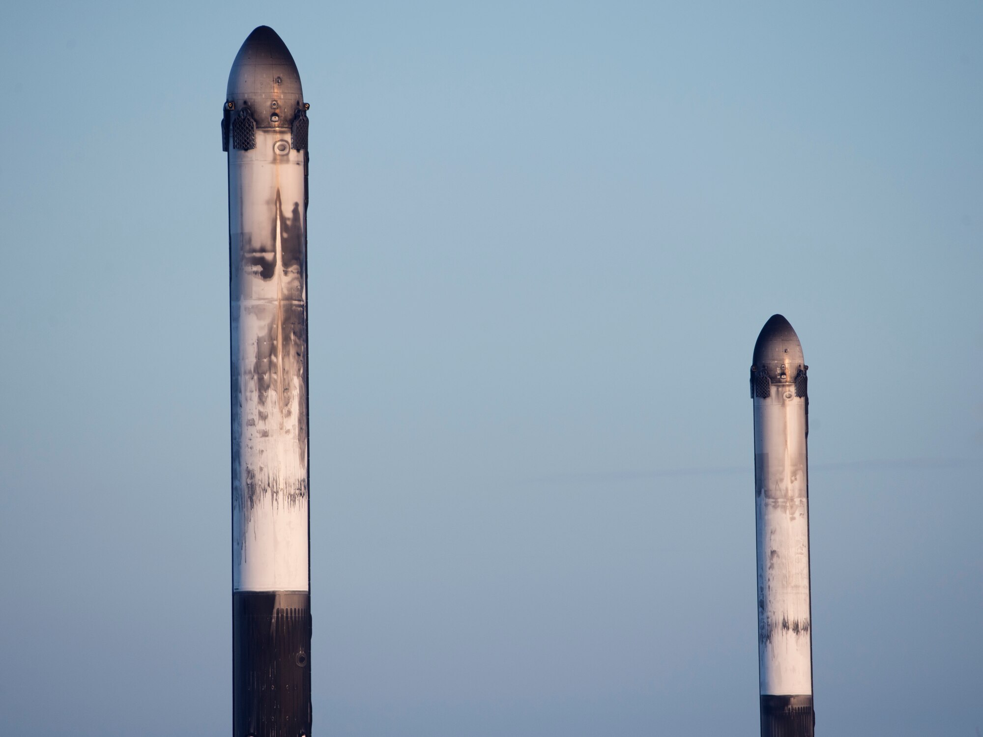 Two boosters sit atop a landing zone after the successful launch and landing of SpaceX's Falcon Heavy Arabsat 6A on April 12, 2019 at Kennedy Space Center, Fla. This marks the second launch of the Falcon Heavy rocket; the most powerful space vehicle flying today. (U.S. Air Force photo by 2nd Lieutenant Alex Preisser)