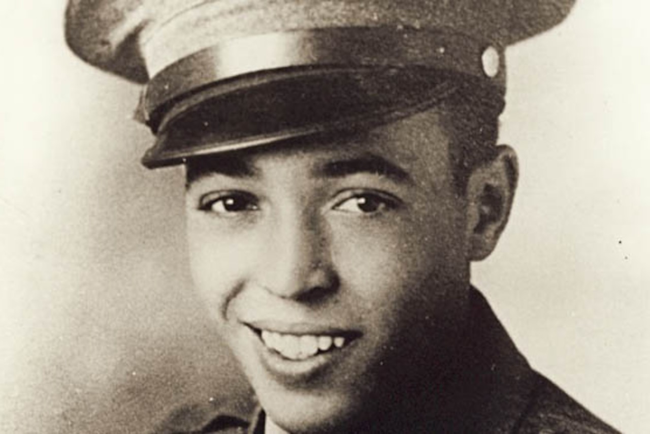 A Marine in his dress cap smiles.