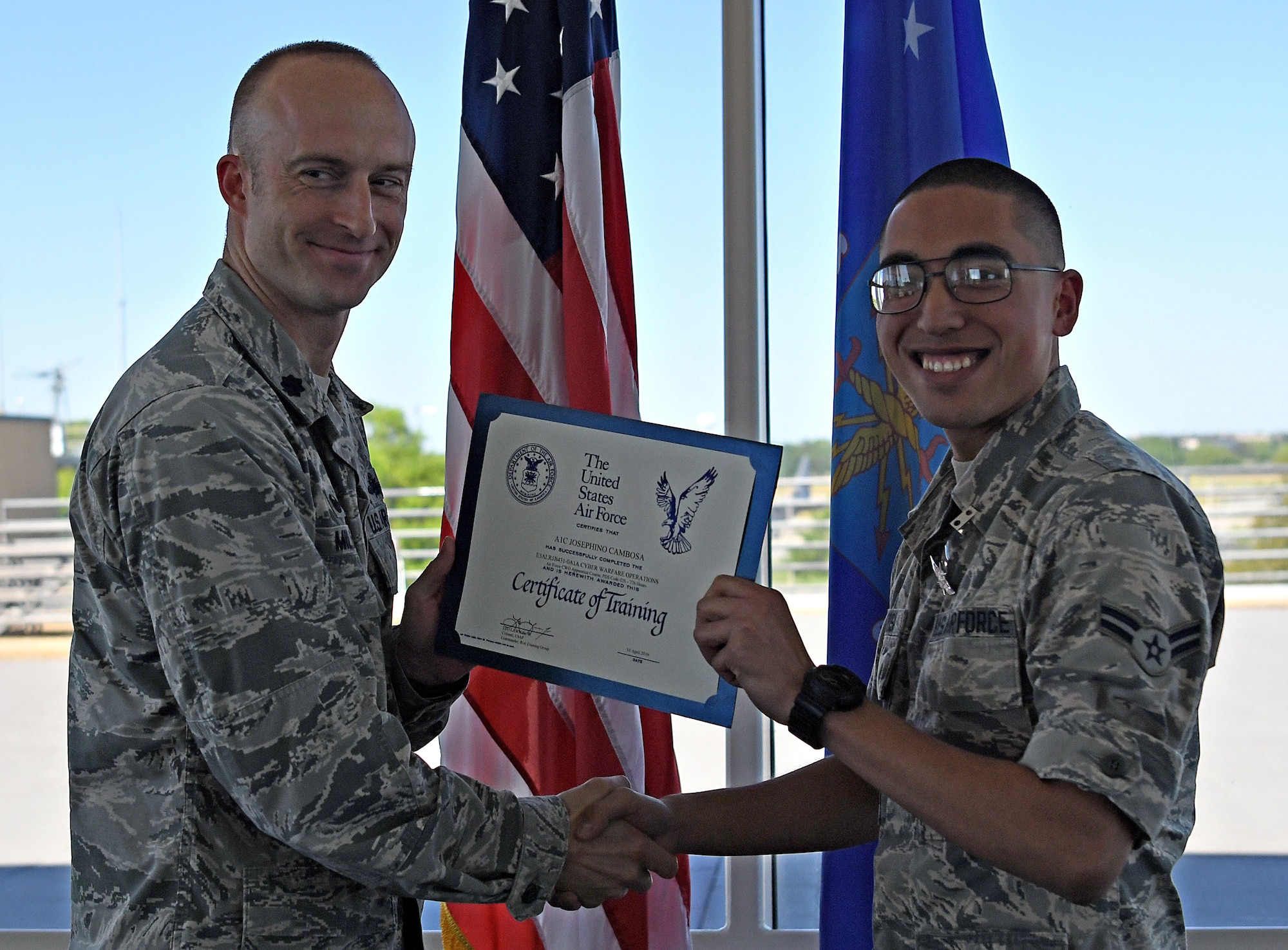 Lt. Col. Andrew Miller, 333rd Training Squadron commander, awards Airman 1st Class Josephino Cambosa, 333rd TRS student, a certificate of training for completing the Cyber Warfare Operations course on Keesler Air Force Base, Mississippi, April 10, 2019. Cambosa is the first non-prior service Airman to graduate from the Cyber Warfare Operations school house. (U.S. Air Force photo by 2nd Lt. Anh T. Bui)